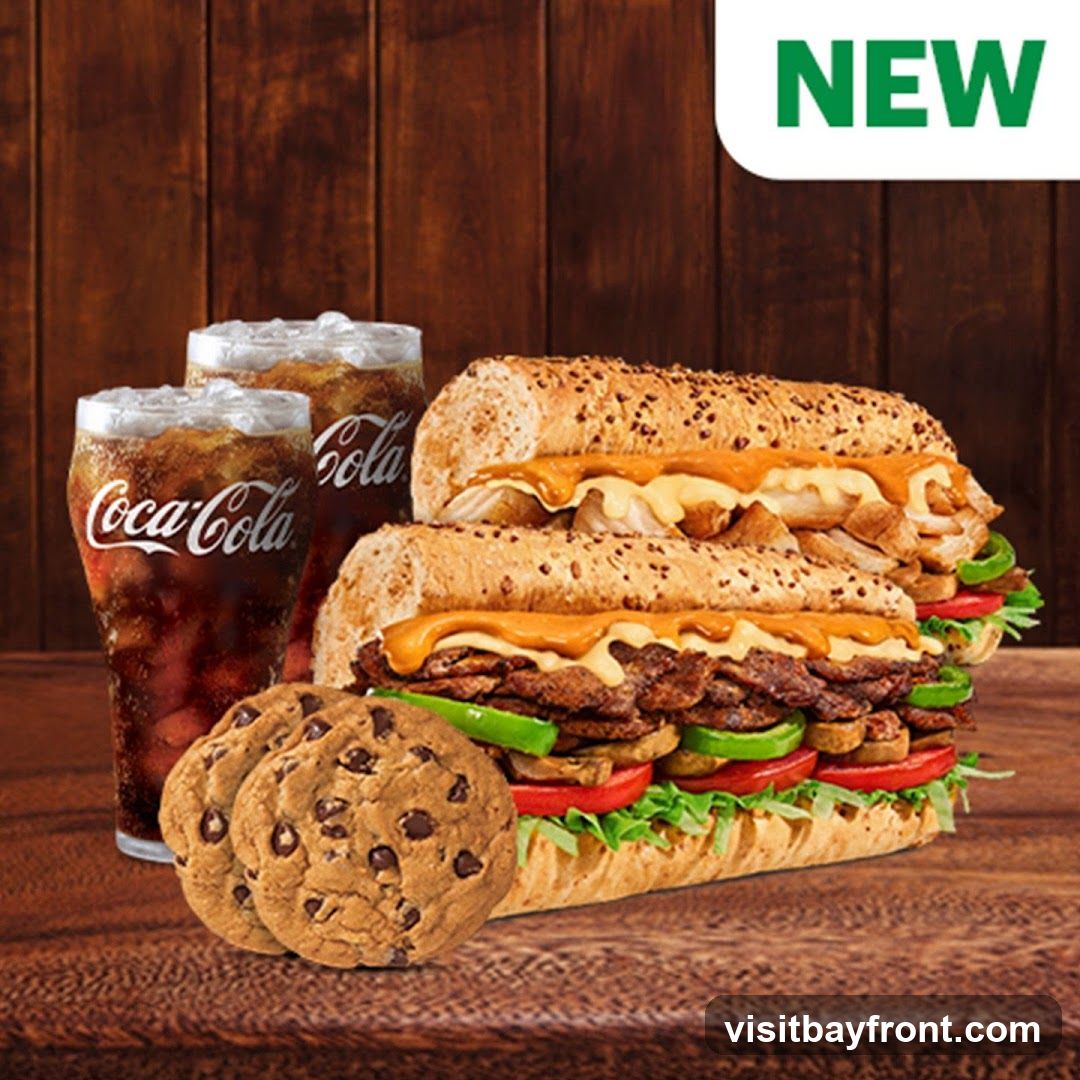 A breakfast sandwich is shown on a white background. The sandwich is made with a folded flatbread, scrambled eggs, melted cheese, tomato slices, and a sausage patty.