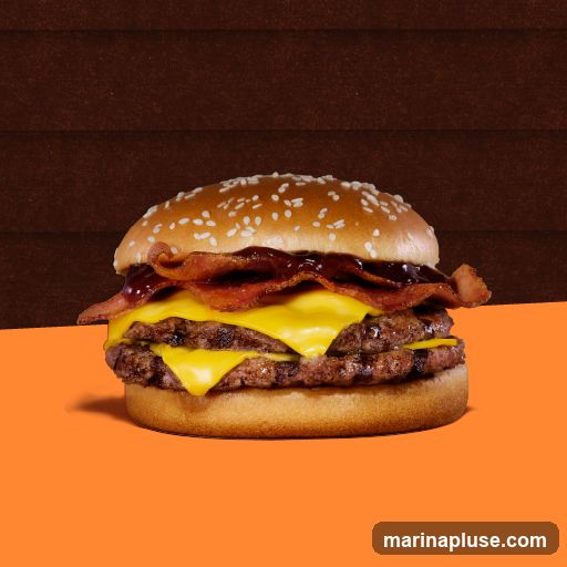 A close-up shot of a double bacon cheeseburger with melted cheese, bacon, and sauce on a sesame seed bun. The burger is placed on an orange surface with a dark brown textured background.
