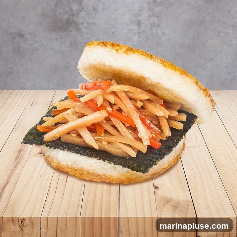 A close-up shot of an onigirazu, a Japanese rice sandwich, filled with pickled vegetables and nori seaweed. The sandwich is placed on a wooden surface against a grey, textured background.
