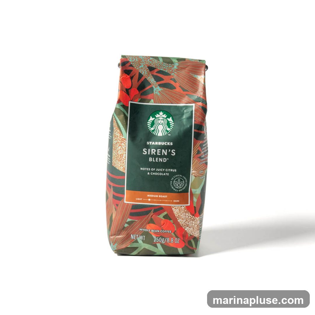 A bag of Starbucks Siren's Blend whole bean coffee with a colorful, botanical-themed design. The bag features the Starbucks logo and details about the blend, including notes of juicy citrus and chocolate, and a medium roast level. The net weight is 250g/8.8 OZ.