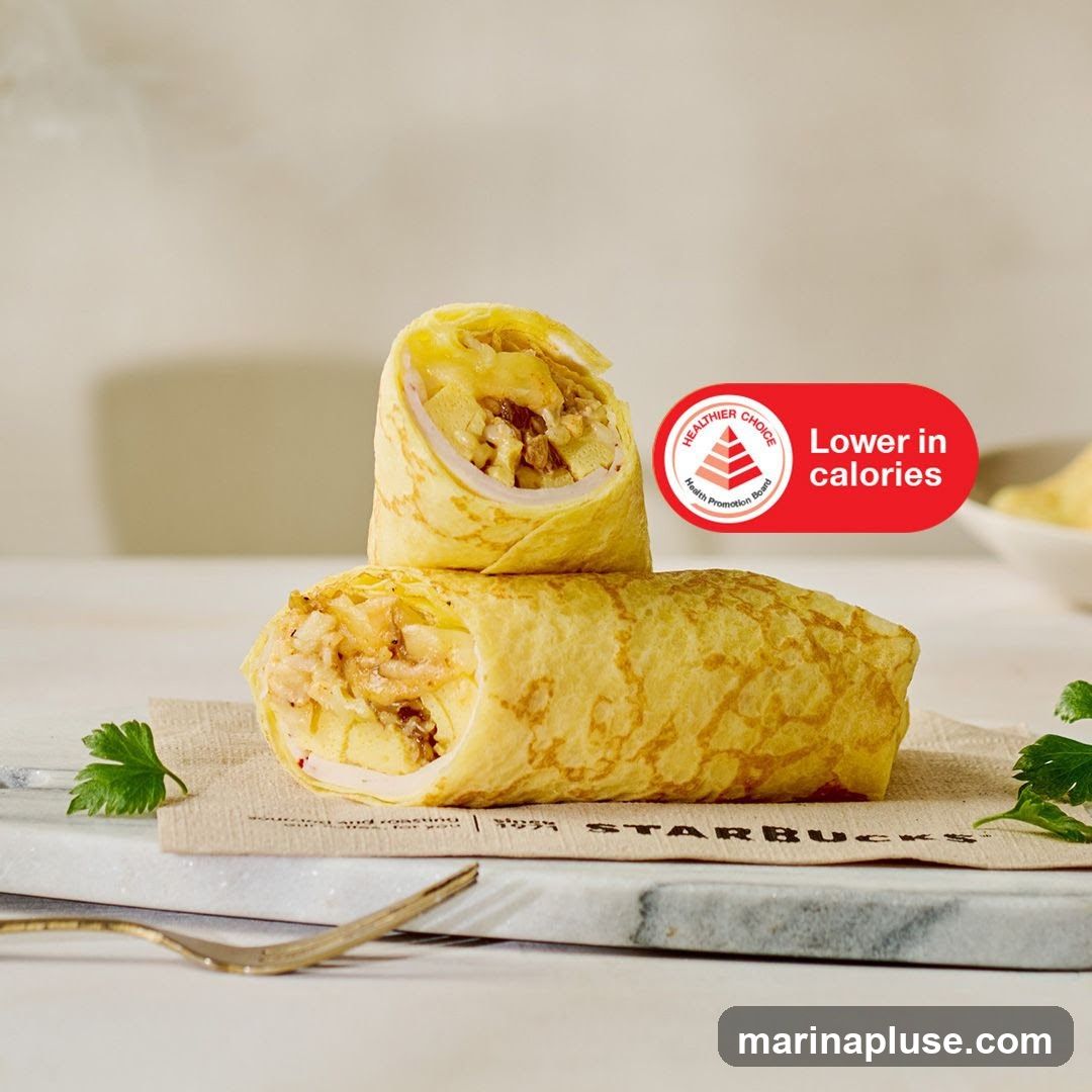 Two wraps are shown, one stacked on top of the other, on a Starbucks branded napkin. The wraps appear to be filled with a savory mixture. A red oval sticker on the right side of the image reads "Healthier Choice" and "Lower in calories". A fork is visible in the lower left corner.