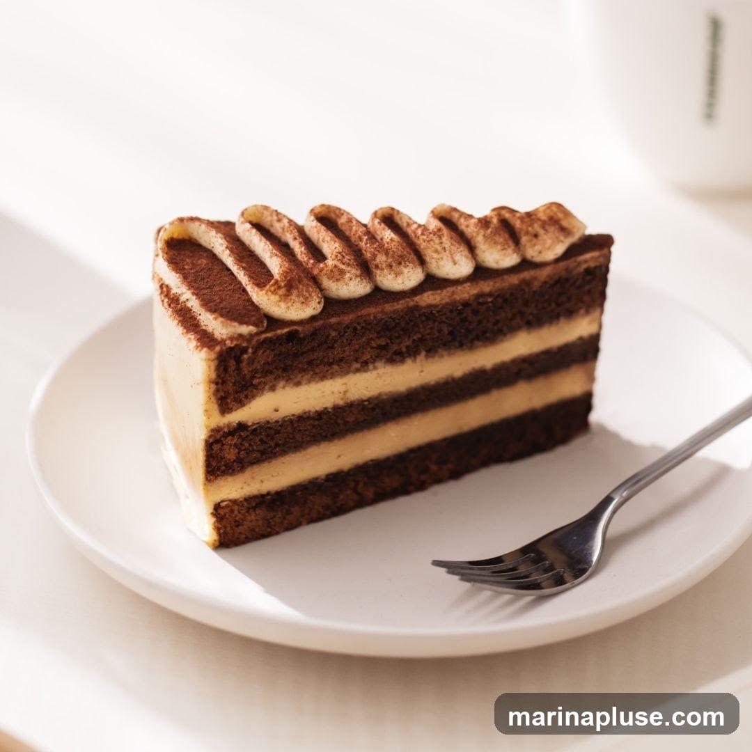 A slice of tiramisu cake on a white plate with a fork. The cake has layers of chocolate cake and cream, topped with whipped cream and dusted with cocoa powder.