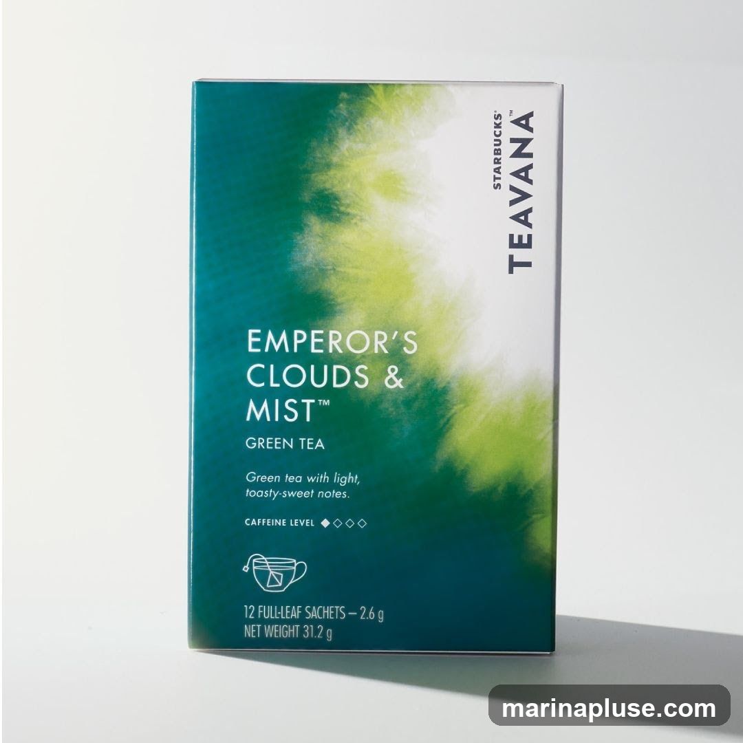 A box of Starbucks Teavana Emperor's Clouds & Mist Green Tea. The box features a gradient of dark teal to light green with abstract cloud-like patterns. Text on the box indicates it is green tea with light, toasty-sweet notes and a medium caffeine level. It contains 12 full-leaf sachets, with a net weight of 31.2 g.