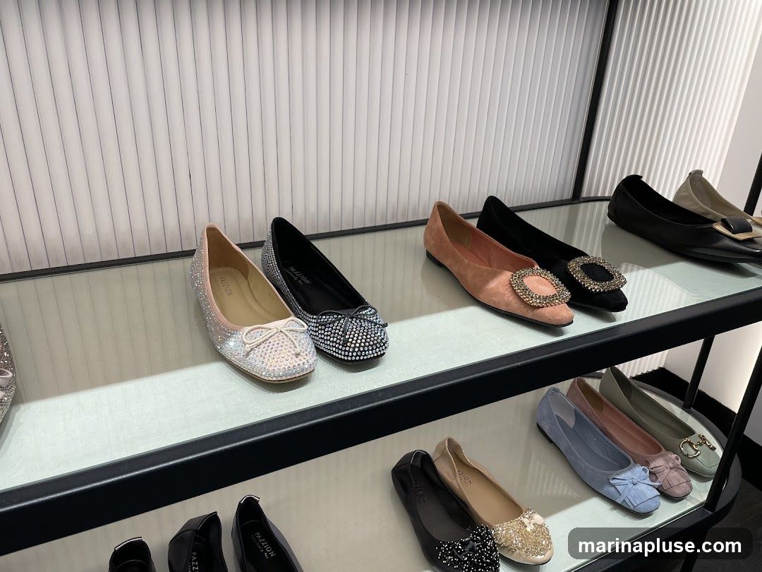 A display of various women's flat shoes on shelves. The shoes include styles with rhinestones, bows, and decorative buckles. Some shoes are in shades of pink, black, silver, blue, and green.