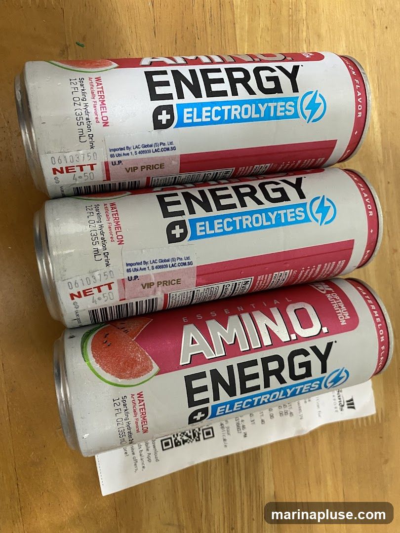 Three cans of watermelon flavored energy drinks with electrolytes. A receipt is visible underneath the bottom can.