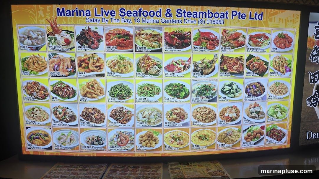 A brightly lit menu board displaying various seafood and steamboat dishes with accompanying images and descriptions in English and Chinese. The menu includes categories like crabs, prawns, fish, vegetables, and fried rice.