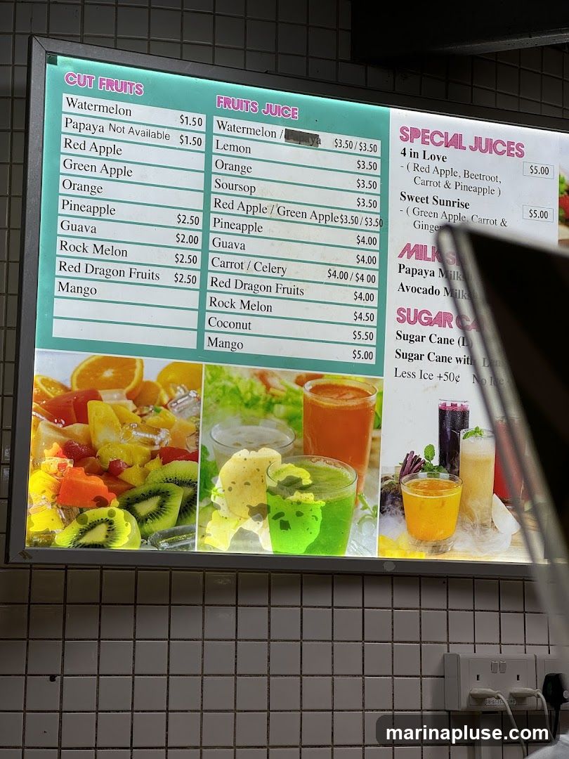 A menu board displaying cut fruits, fruit juices, special juices, milks, and sugar cane drinks.