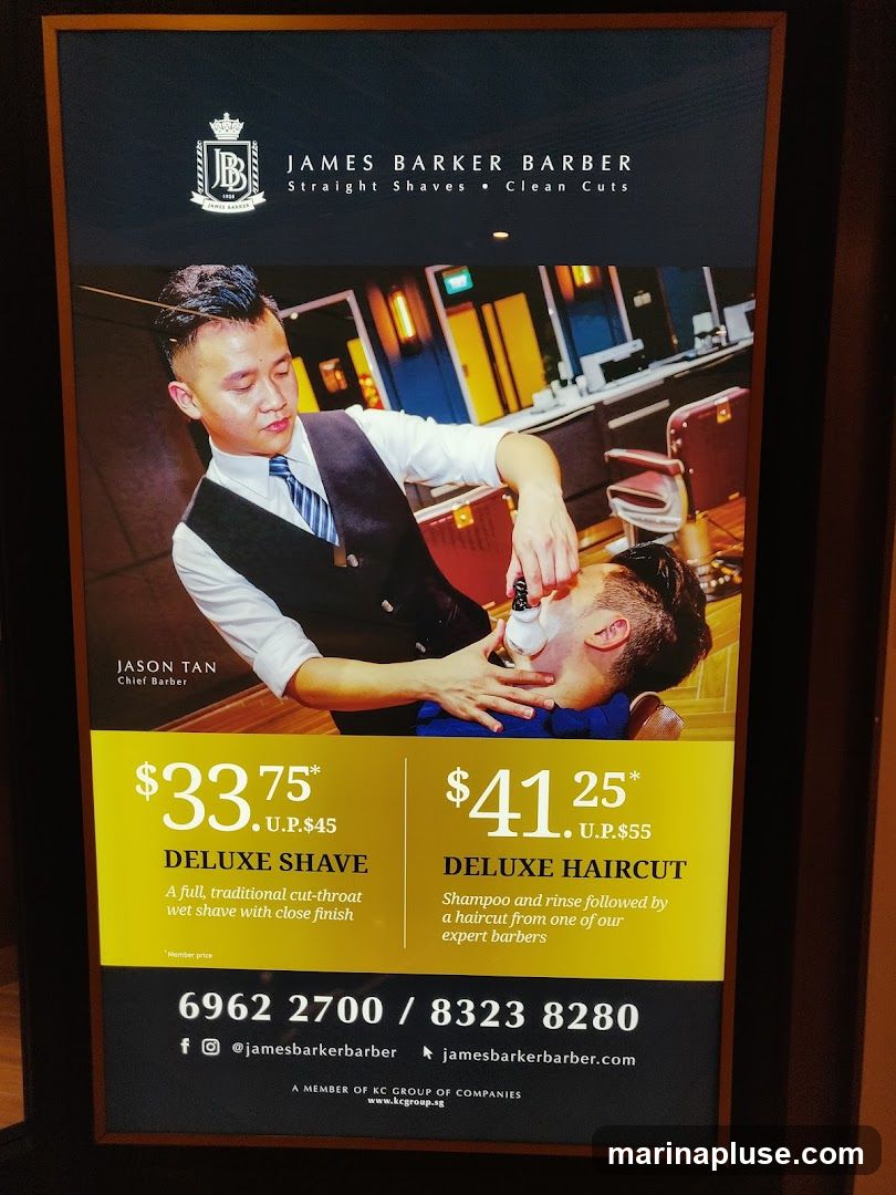 An advertisement for James Barker Barber featuring a barber performing a shave on a client. The ad highlights two services: Deluxe Shave for $33.75 (U.P. $45) and Deluxe Haircut for $41.25 (U.P. $55). Contact information and website are also displayed.