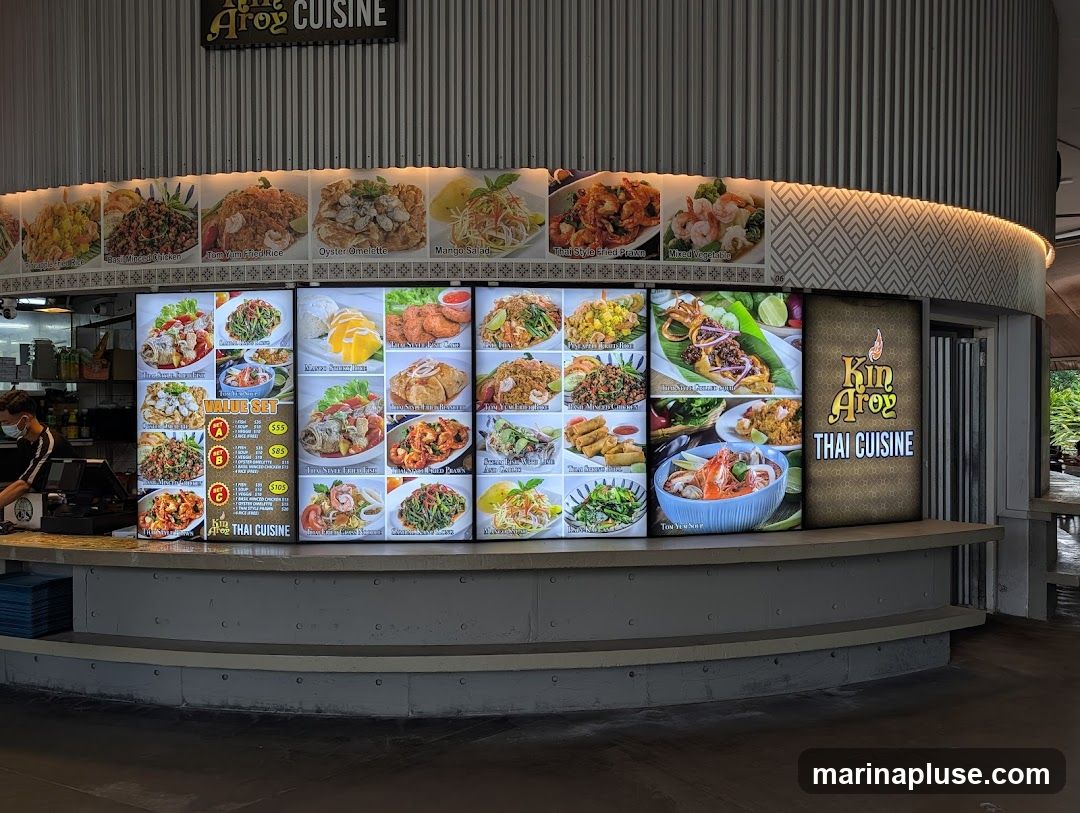A digital menu board displaying various Thai dishes with images and prices.
