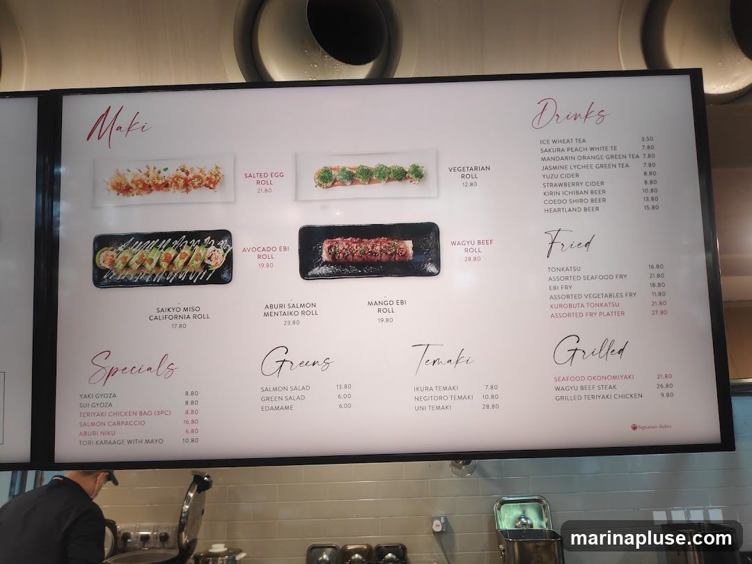 A menu board with sections for Maki, Specials, Greens, Temaki, Drinks, Fried, and Grilled items.
