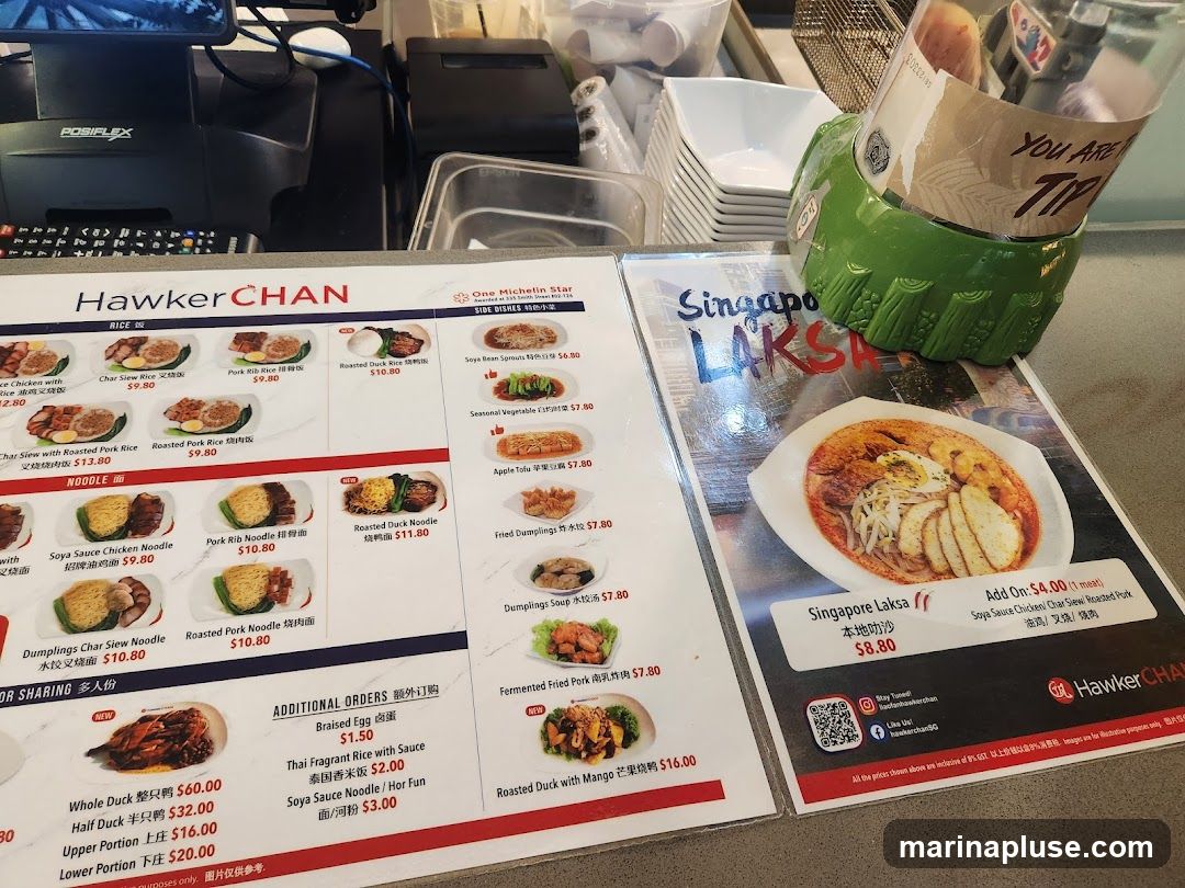 A menu from Hawker CHAN featuring rice, noodle, side dishes, and additional orders. It also highlights Singapore Laksa.