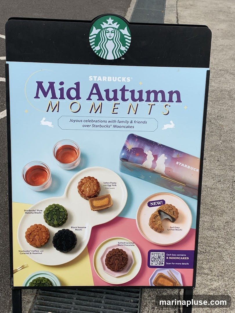 A promotional sign for Starbucks Mid Autumn Moments featuring various mooncakes and mochi flavors. The sign displays images of Lotus Paste with Egg Yolk, Starbucks Pure Matcha Mochi, Black Sesame Mochi, Starbucks Coffee Caramel & Hazelnut, Salted Caramel Dark Chocolate, and Earl Grey Lychee Mochi. It also shows two glasses of tea and a decorative box. A QR code is present for more details about the 8-piece mooncake boxes.