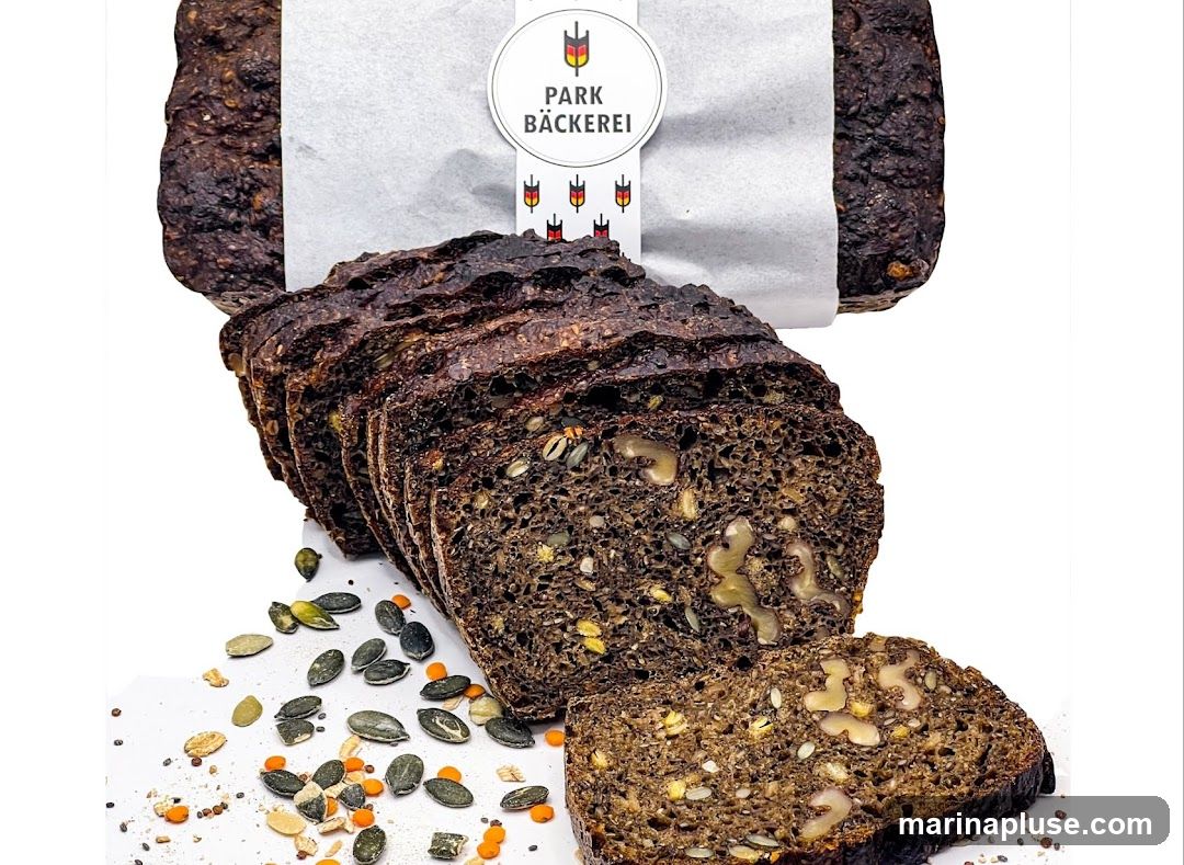 A loaf of dark, seeded bread, sliced, with a label that reads "PARK BÄCKEREI". Scattered seeds and lentils are visible around the bread.