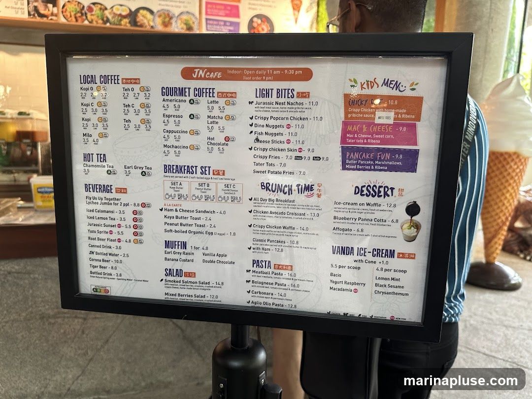 A framed menu board for JN Cafe, featuring sections for Local Coffee, Gourmet Coffee, Hot Tea, Beverages, Breakfast Sets, Light Bites, Brunch Time, Kids Menu, Desserts, and Pasta.