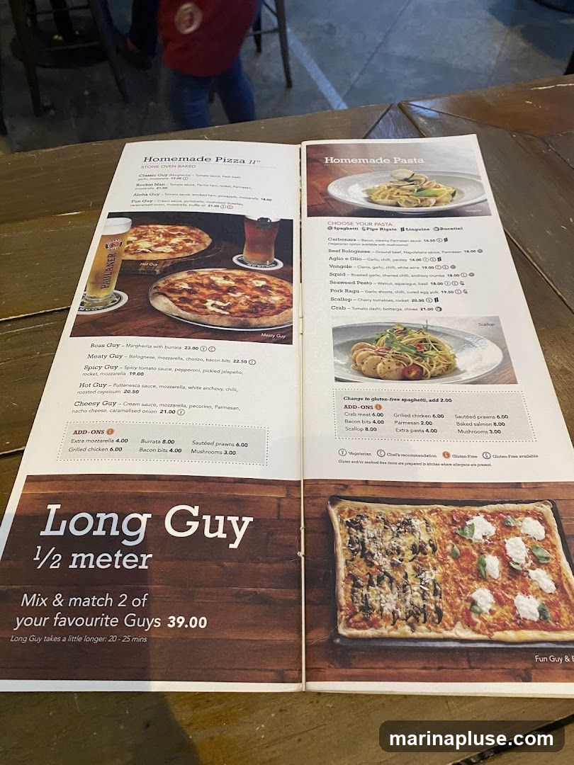 A menu featuring homemade pizzas and pastas. Pizzas include options like Classic Guy, Meaty Guy, and Spicy Guy. Pasta options include Spaghetti, Pipe Rigate, Linguine, and Bucatini with various sauces and ingredients. There is also a "Long Guy 1/2 meter" pizza option.