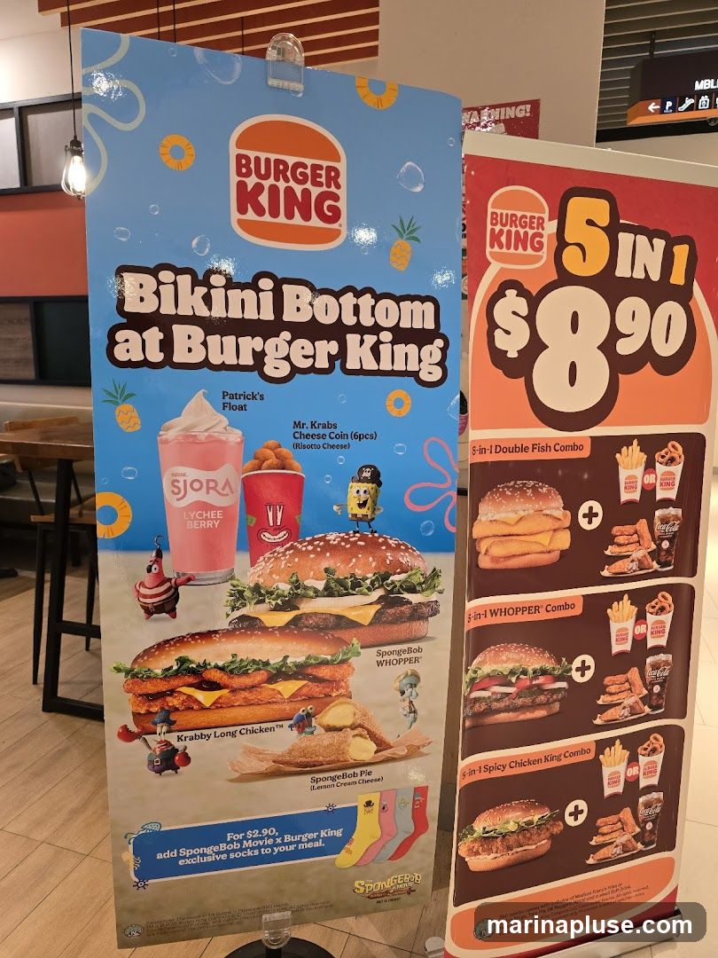 A promotional display for Burger King's "Bikini Bottom at Burger King" collaboration with Spongebob Squarepants. The display features images of themed food items like the Krabby Long Chicken, Spongebob WHOPPER, and Spongebob Pie, along with a Patrick's Float drink and Mr. Krabs Cheese Coins. It also advertises a "5 in 1" combo deal for $8.90, offering various combo options. Additionally, there's an offer to add exclusive Spongebob socks to a meal for $2.90.
