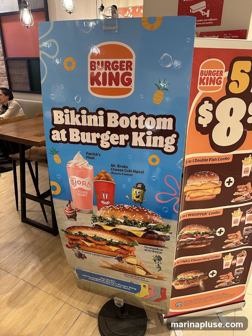 A promotional display for Burger King's 'Bikini Bottom at Burger King' collaboration, featuring Spongebob Squarepants characters. The display showcases various food items including a Patrick's Float, Mr. Krabs Cheese Coin, Krabby Long Chicken, SpongeBob WHOPPER, and SpongeBob Pie. It also advertises combo meals like the 5-in-1 Double Fish Combo, 5-in-1 WHOPPER Combo, and 6-in-1 Spicy Chicken King Combo. A special offer for exclusive Spongebob socks is also mentioned.