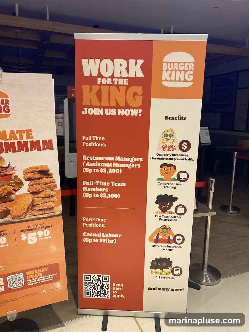 A vertical banner displays recruitment information for Burger King. The banner is divided into sections, with the left side detailing job positions and the right side listing benefits. The Burger King logo is prominently featured. On the left, it advertises full-time positions for Restaurant Managers/Assistant Managers (up to $3,200) and Full-Time Team Members (up to $2,100). Part-time positions include Casual Labour (up to $9/hr). The benefits section highlights Quarterly Incentives, Comprehensive Training, Fast Track Career Progression, Attractive Insurance Package, and CIS Programs. A QR code is provided for application. To the left of the main banner, another partial banner shows food items, including BK Nuggets.