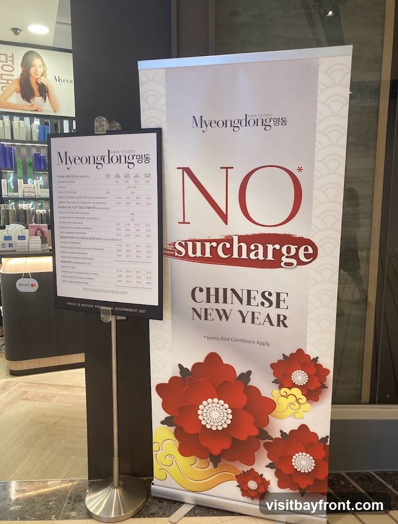 A promotional banner for Myeongdong Hair Studio advertises "NO surcharge" for Chinese New Year. The banner features large red floral designs and the salon's logo. A separate menu board displays prices for various hair services.