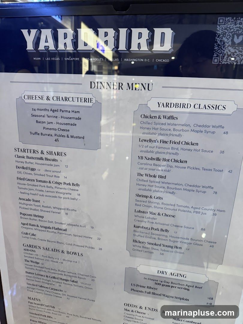 A dinner menu for Yardbird restaurant with sections for Cheese & Charcuterie, Starters & Shares, Garden Salads & Bowls, Mains, Yardbird Classics, Dry Aging, and Odds & Ends.