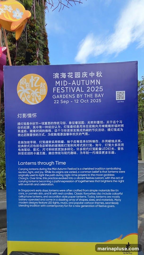A purple sign with white text details the Mid-Autumn Festival at Gardens by the Bay from September 22 to October 12, 2025. It includes information in both Chinese and English about the tradition of carrying lanterns, their origins, and how they have evolved over time. The sign also features a logo with palm trees and the text "同在忆起" (Together in Memory) and "滨海花园" (Gardens by the Bay). A QR code is present with a "Learn More" option. The bottom of the sign has a yellow section with the Gardens by the Bay logo.