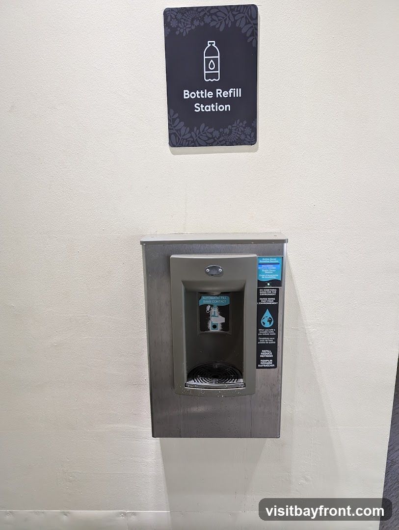 A sign above a metal bottle refill station indicates its purpose. The station has a sensor for automatic filling and instructions for use.