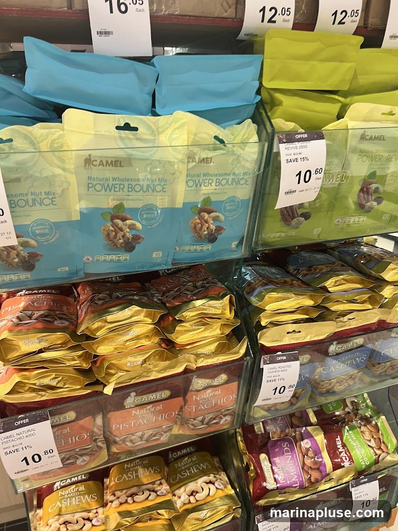 Shelves stocked with various Camel brand nut mixes, pistachios, cashews, and almonds. Some products are on offer with discounted prices displayed.
