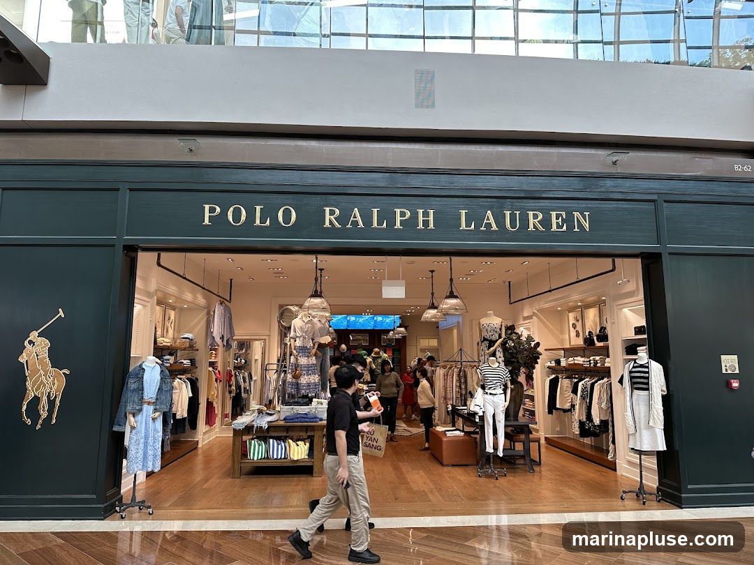 The exterior of a Polo Ralph Lauren store with the brand name prominently displayed above the entrance. The store features a large Polo player logo on the left side of the facade. Inside, clothing racks and mannequins display various apparel items.