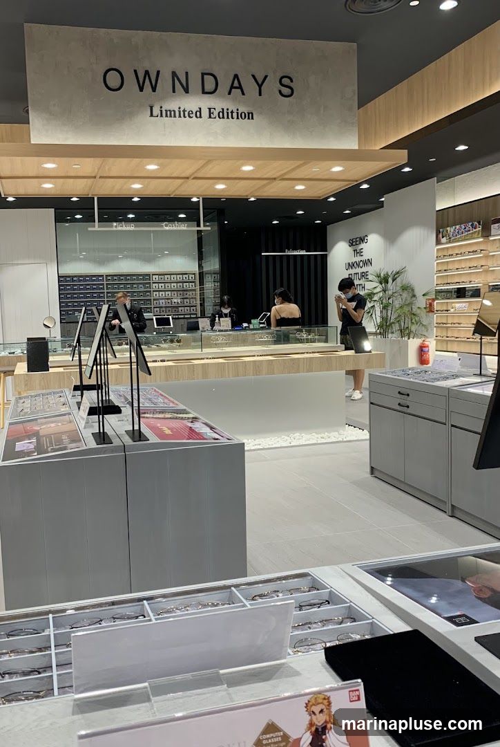 An interior view of an eyewear store. The store features displays of eyeglasses and sunglasses. A sign above reads "OWNDAYS Limited Edition." Several customers and staff members are visible.