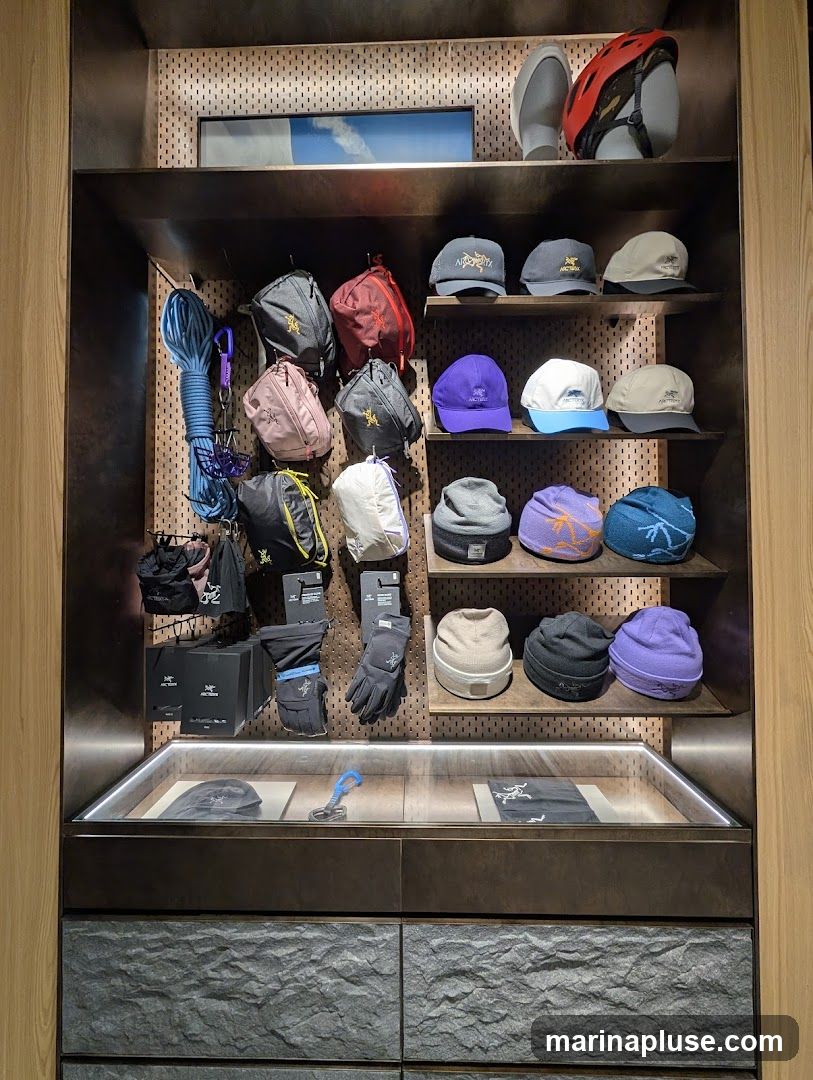 A retail display featuring outdoor gear, including backpacks, hats, gloves, helmets, and climbing ropes. The items are neatly arranged on shelves and a pegboard wall.