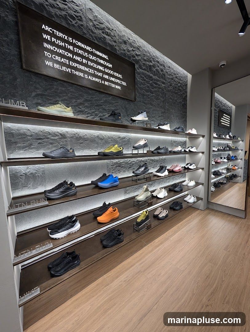 A well-lit interior of a shoe store with shelves displaying various athletic shoes. The walls are textured, and a large sign with text about the brand's philosophy is prominently displayed. The floor is made of wood-look planks.