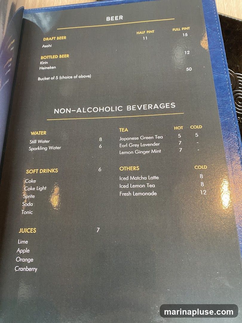 Menu featuring draft and bottled beers, as well as a selection of non-alcoholic beverages including water, tea, soft drinks, and juices.