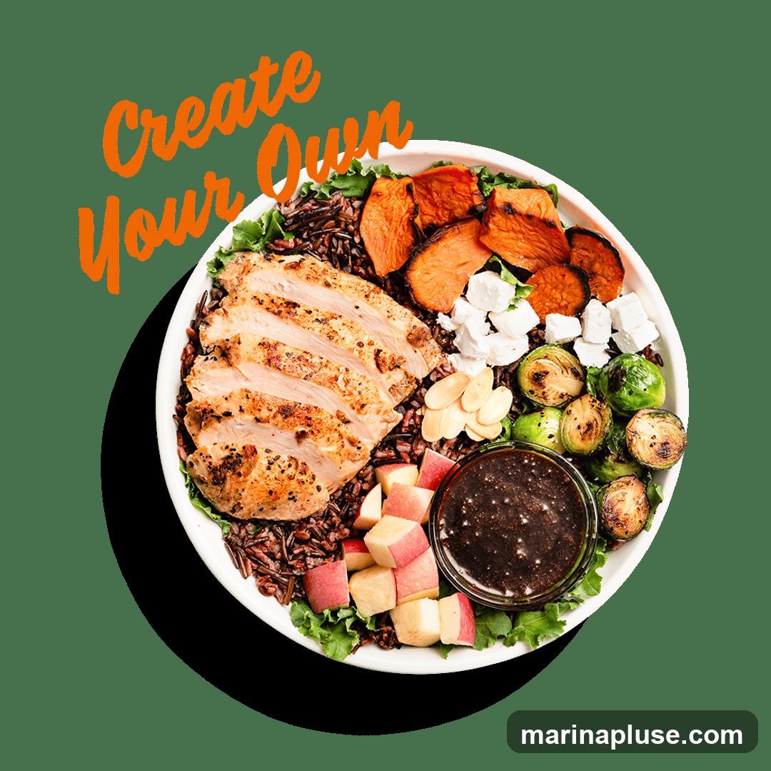 A bowl of food with sliced grilled chicken, wild rice, roasted sweet potatoes, feta cheese, Brussels sprouts, sliced almonds, diced apples, and a dark dressing. The text "Create Your Own" is overlaid on the image.