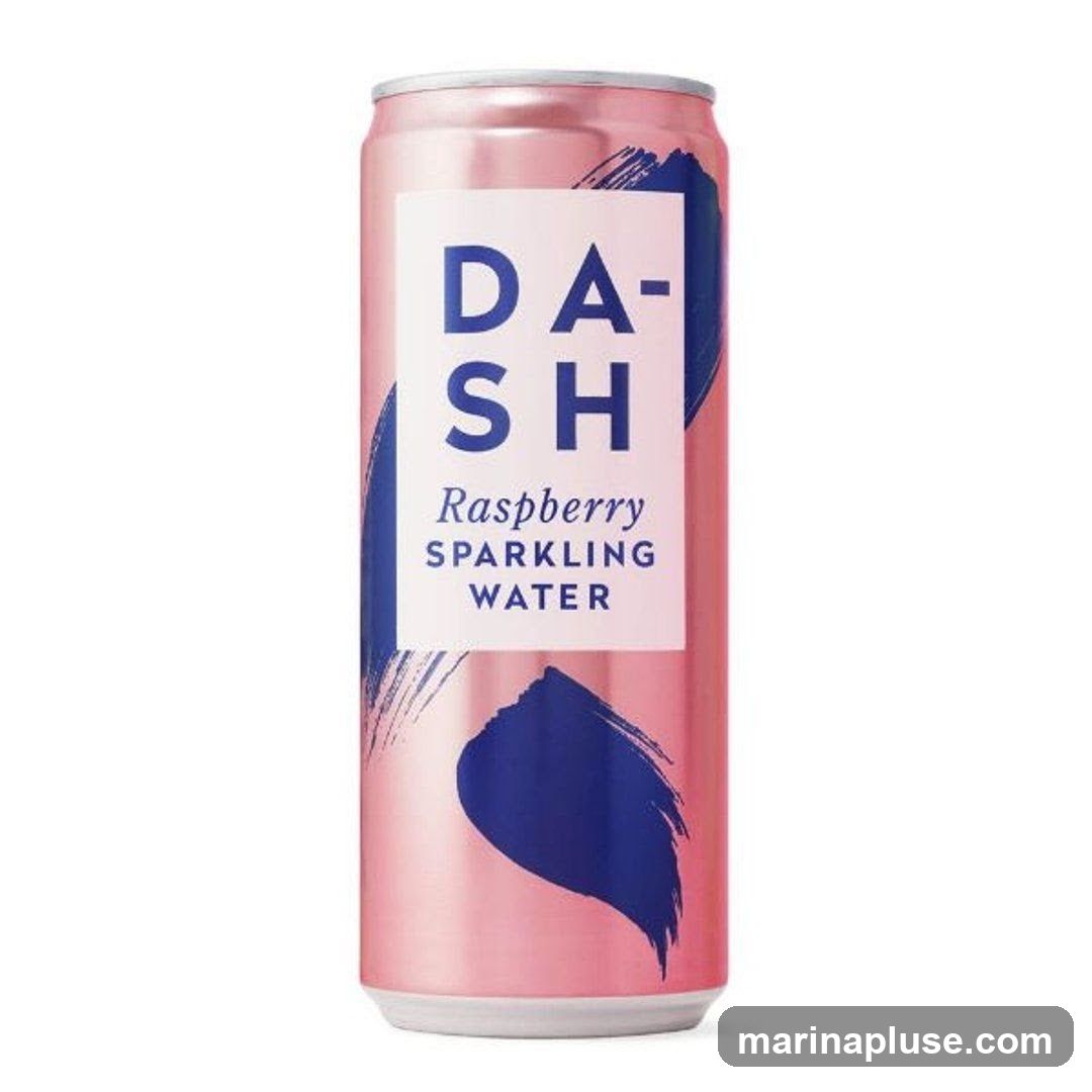 A pink can of Dash Raspberry Sparkling Water with blue brushstroke accents. The label features the brand name "DASH" in large blue letters, followed by "Raspberry SPARKLING WATER" in smaller text.