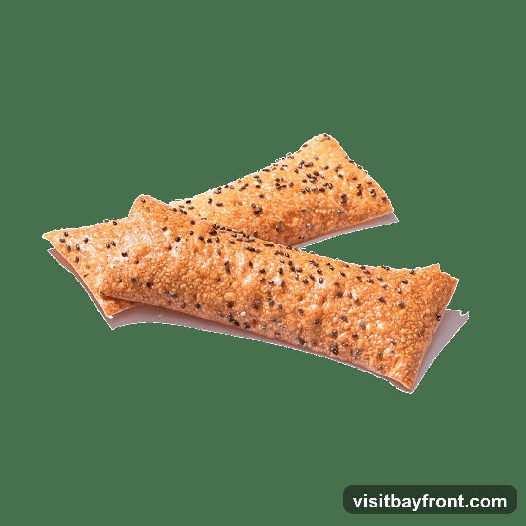 Two golden-brown pastries are shown against a black background. The pastries are elongated and appear to be filled. They are sprinkled with numerous small black seeds, likely chia seeds, and possibly sesame seeds. The pastries are slightly overlapping.
