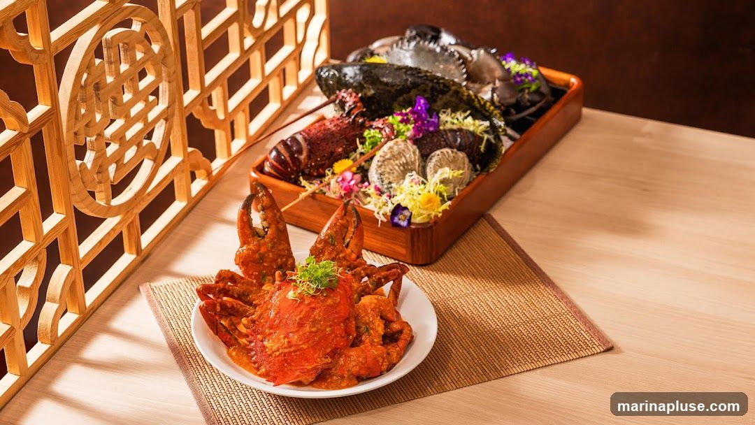 A close-up shot of a seafood platter featuring a whole crab in a rich orange sauce in the foreground, and a larger platter with lobster, crabs, and oysters in the background. The dishes are garnished with fresh herbs and edible flowers, set against a backdrop of a wooden lattice screen and a light-colored wooden table.