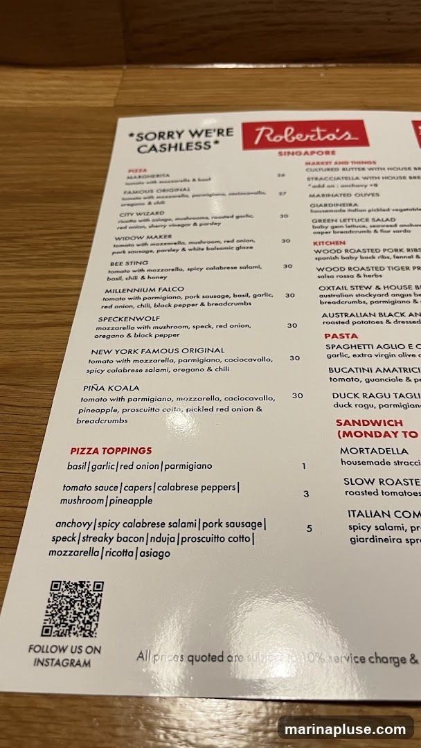 A menu from Roberta's Singapore, with a note stating "Sorry we're cashless". It lists pizzas, pizza toppings, kitchen items, pasta, and sandwiches.