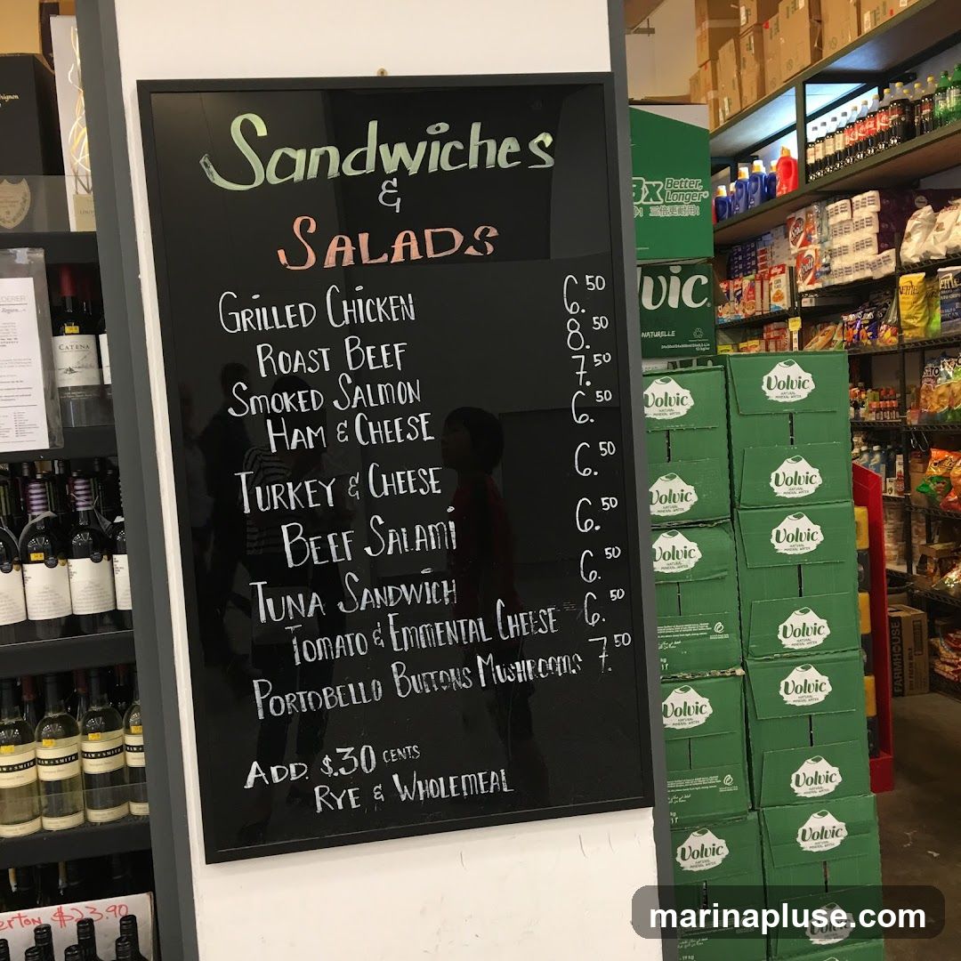 A chalkboard menu displaying various sandwiches and salads with prices.