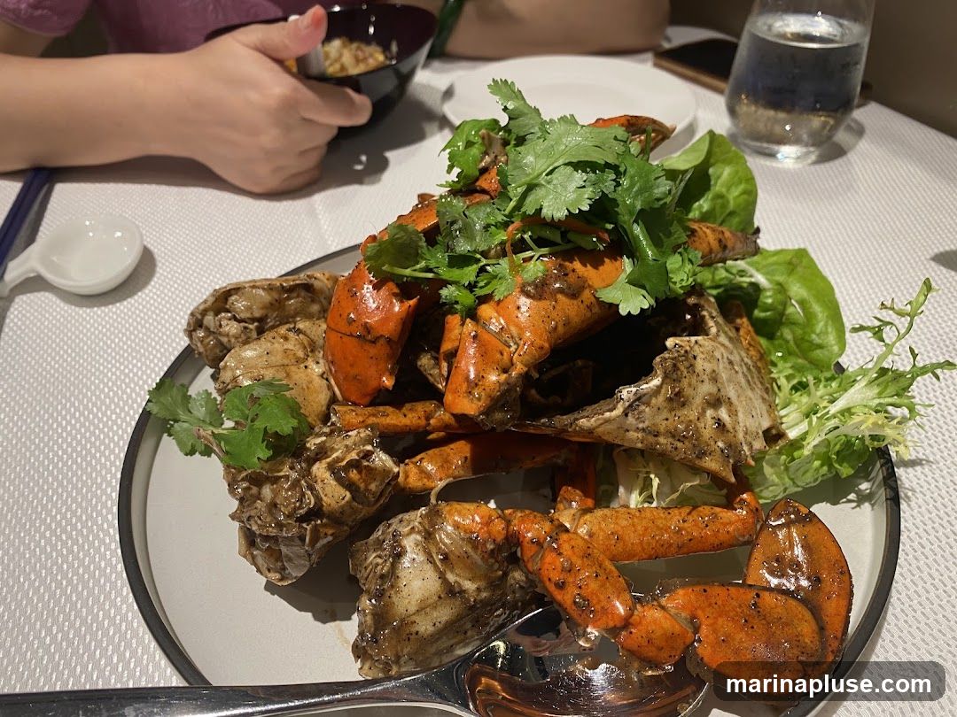 A plate of black pepper crab is served with lettuce and cilantro. A person is seen in the background holding a bowl of rice.