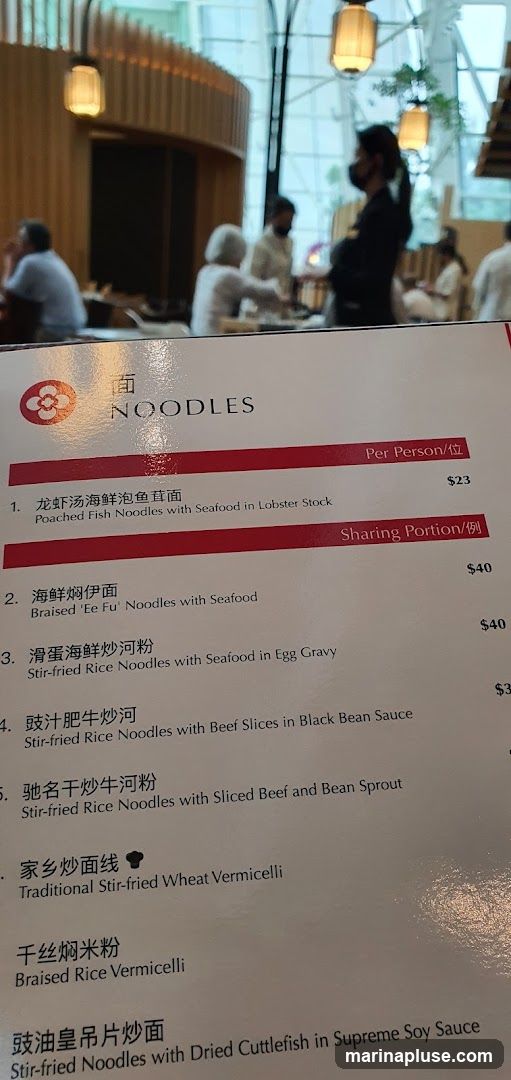 A menu featuring various noodle dishes, with prices listed per person and for sharing portions.