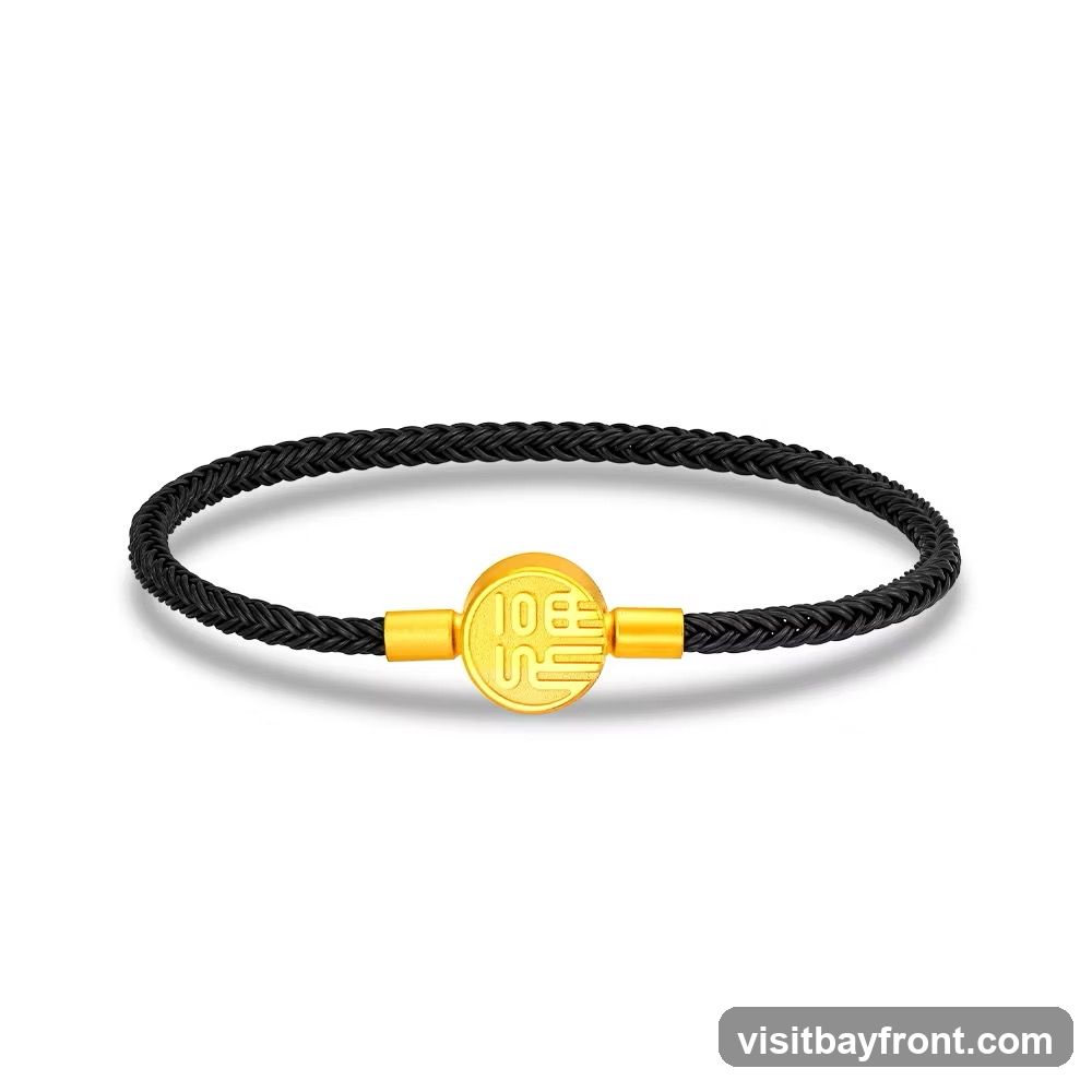 A black braided bracelet with a gold circular charm in the center. The charm has Chinese characters inscribed on it.