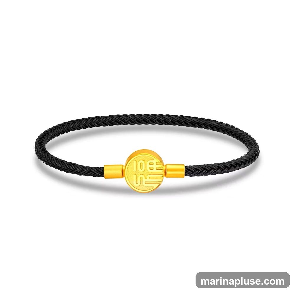 A black braided bracelet with a gold circular charm in the center. The charm has Chinese characters inscribed on it.