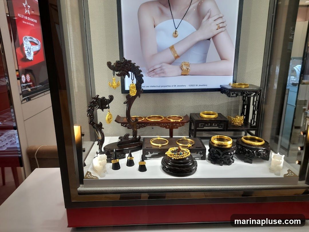 A display case filled with gold jewelry, including bracelets, pendants, and rings. A large advertisement featuring a woman wearing jewelry is visible in the background.