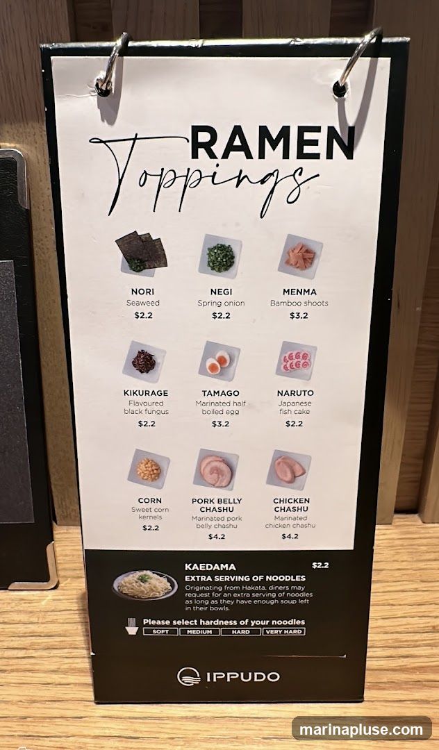 A menu displaying various ramen toppings and an option for an extra serving of noodles.