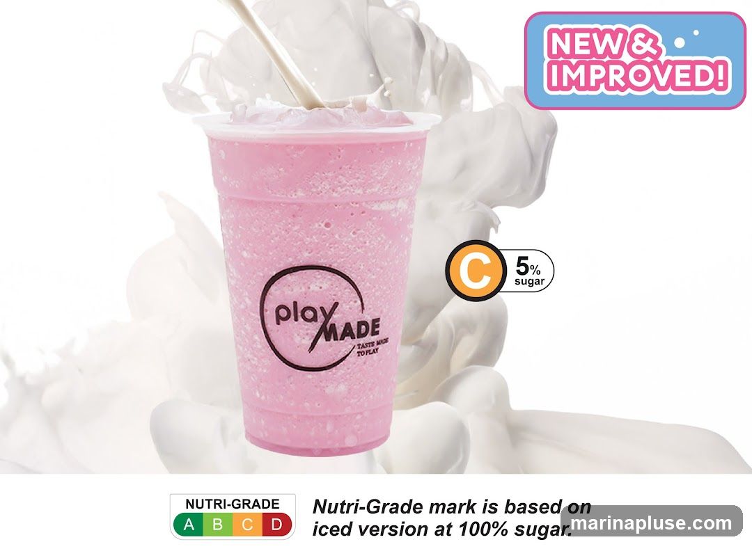 A pink, slushy drink in a clear plastic cup with a straw. The cup has a circular logo that says "play MADE TASTE MADE TO PLAY". Above the drink, a sign reads "NEW & IMPROVED!". To the right of the drink, a circle with a 'C' inside indicates "5% sugar". Below the drink, a Nutri-Grade chart shows A, B, C, and D, with a note explaining the grading system. The background is a white, abstract representation of milk or cream swirling.