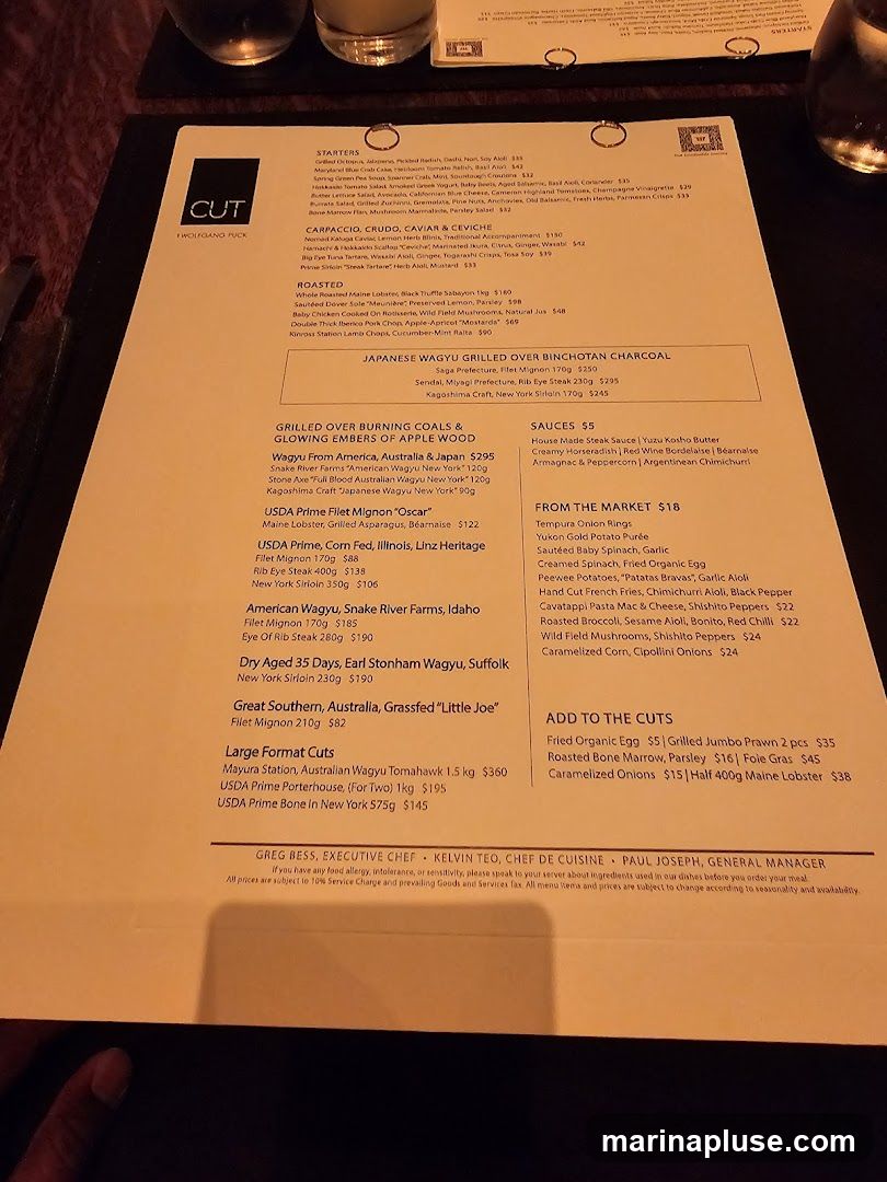 A menu from CUT by Wolfgang Puck featuring starters, carpaccio, crud, ceviche, roasted meats, Japanese Wagyu, and various cuts of steak.