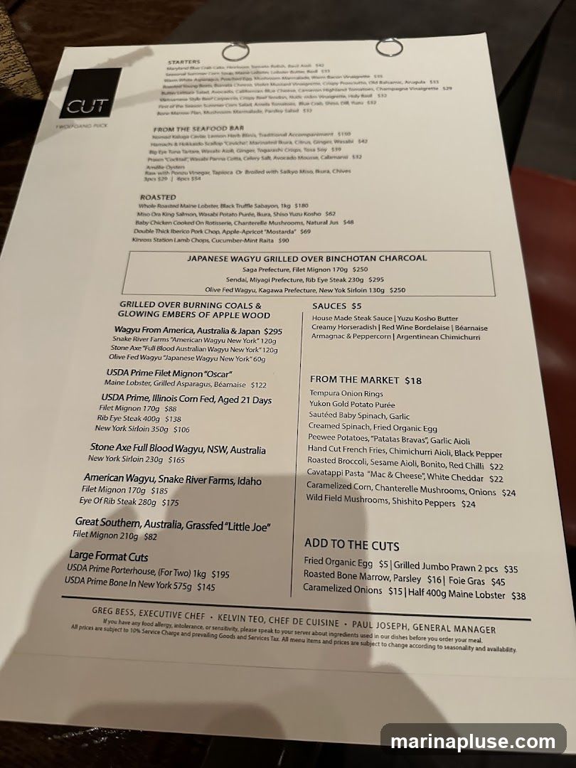 Menu from CUT by Wolfgang Puck. Features starters, seafood, roasted dishes, Japanese Wagyu, and various cuts of steak.