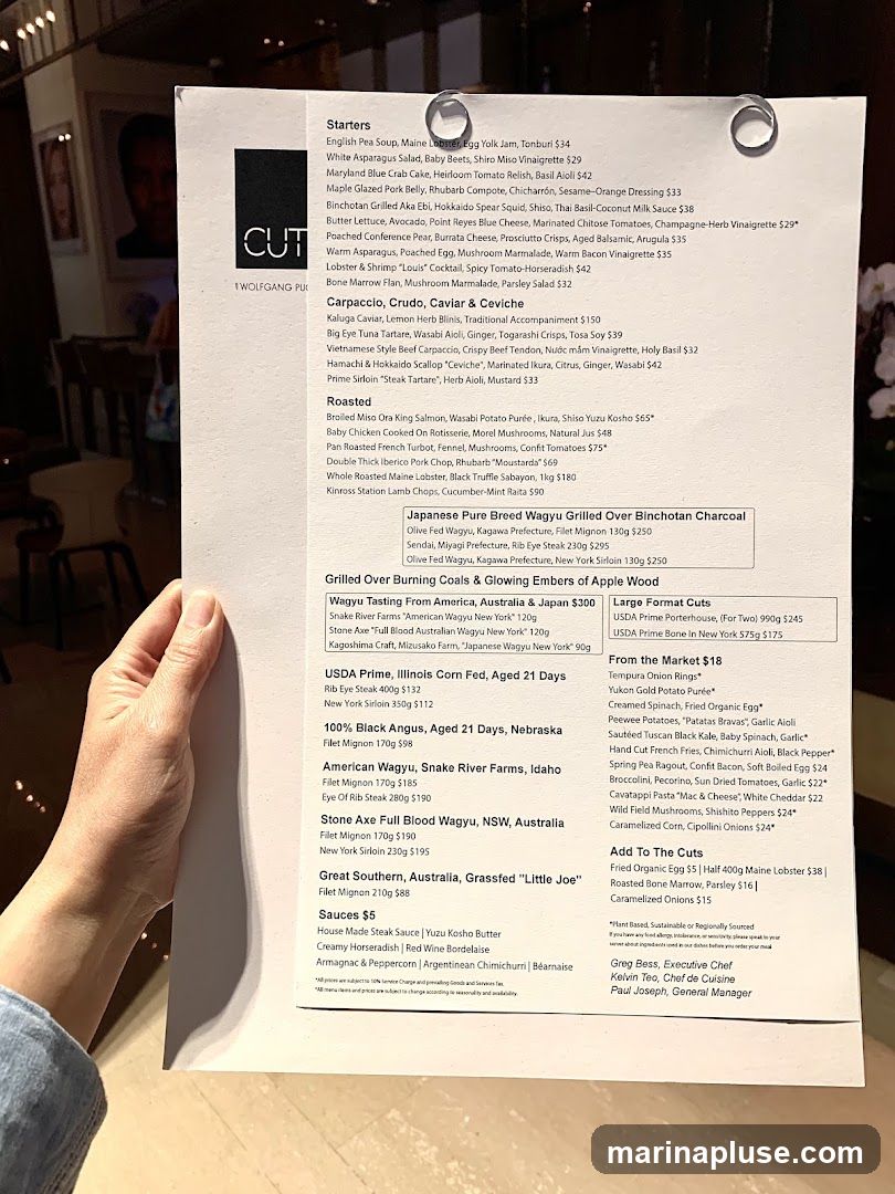 A menu from CUT by Wolfgang Puck featuring starters, carpaccio, crudo, caviar & ceviche, roasted dishes, Japanese Wagyu, USDA Prime steaks, and other cuts.