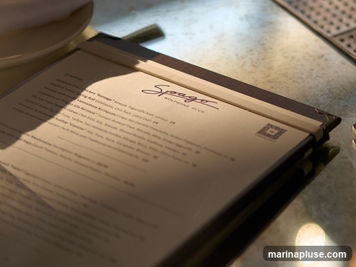 A close-up of a menu from Spago Wolfgang Puck. The menu is open to the starters section.