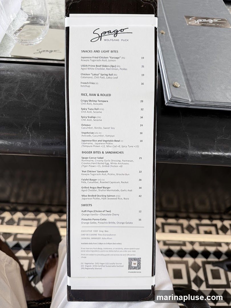 A menu from Spago by Wolfgang Puck featuring snacks, rice dishes, larger bites, and sweets.